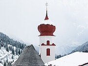 The snowy church steeple in Stuben am Arlberg